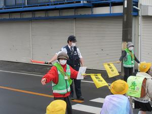 徳力小　制服を着用した警察官とボランティア